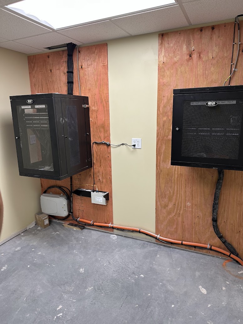 Commercial construction IDF room with two wall-mounted network enclosures and conduit during build-out