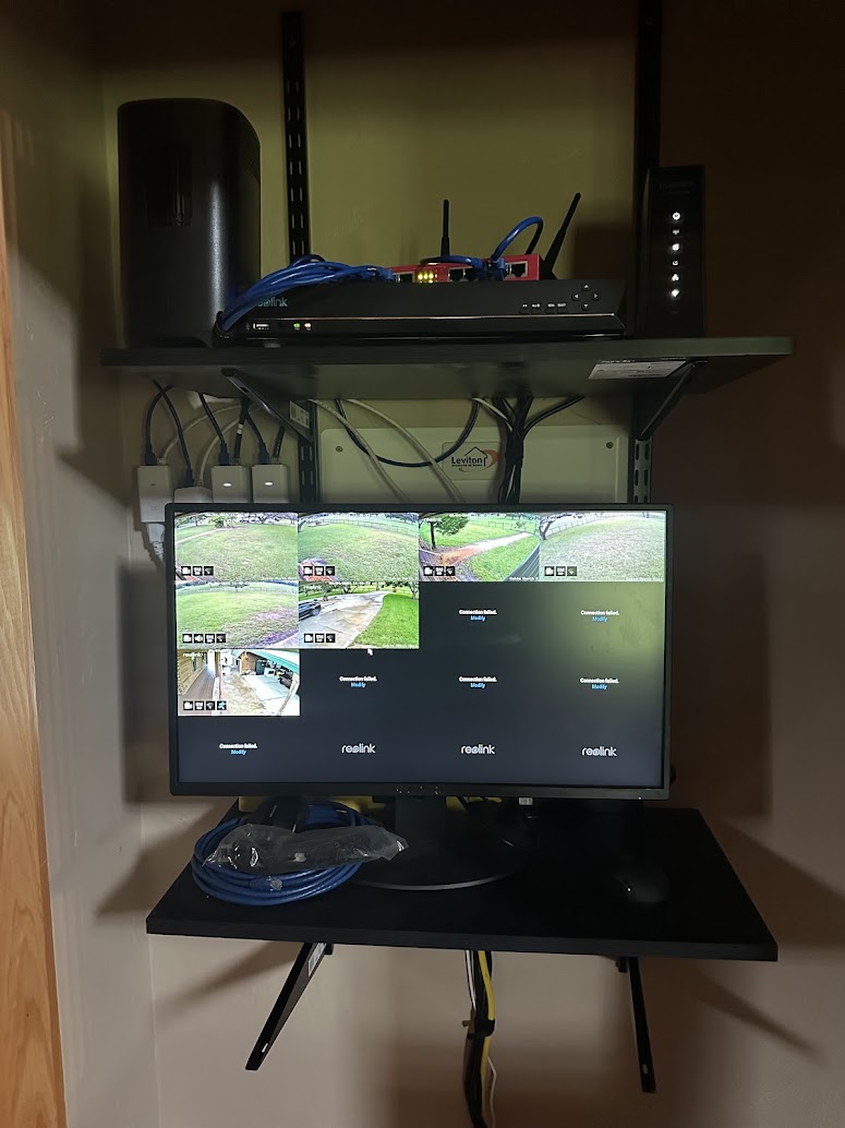 Home security camera system with NVR, network switch, and monitor showing live camera feeds